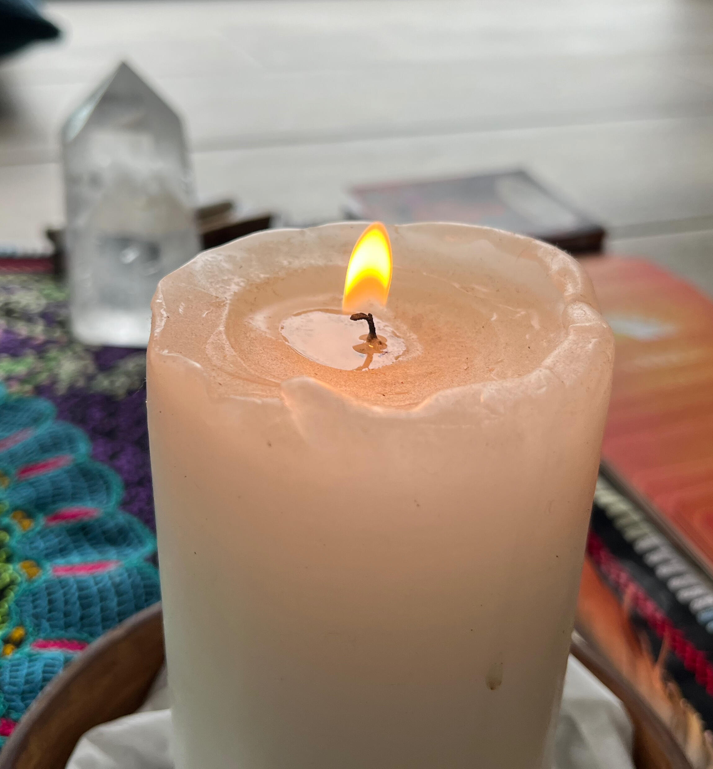 A lit candle on a woven cloth, the quiet centre of the meditation space