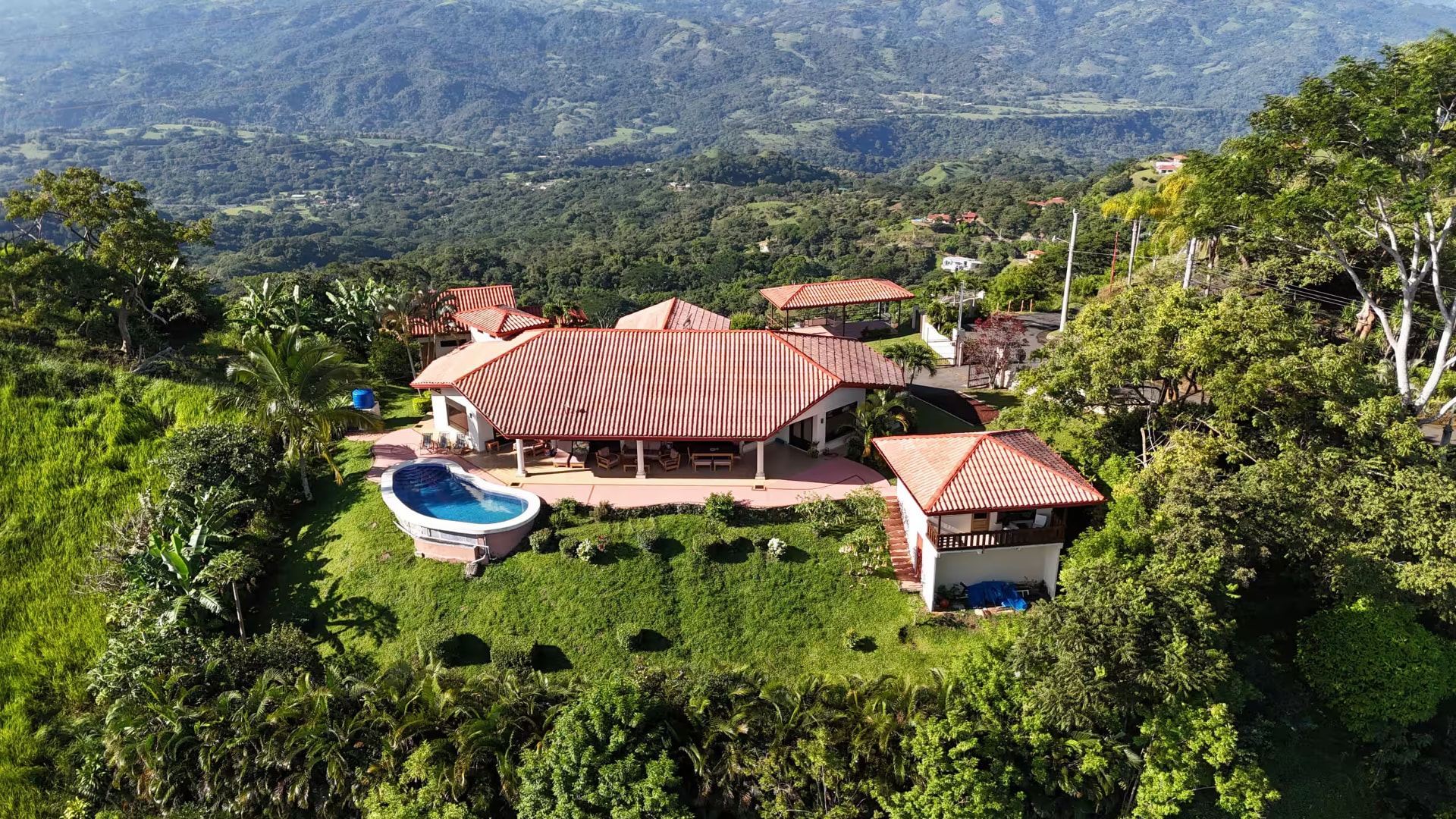Aerial view of the Atenas property surrounded by green hills