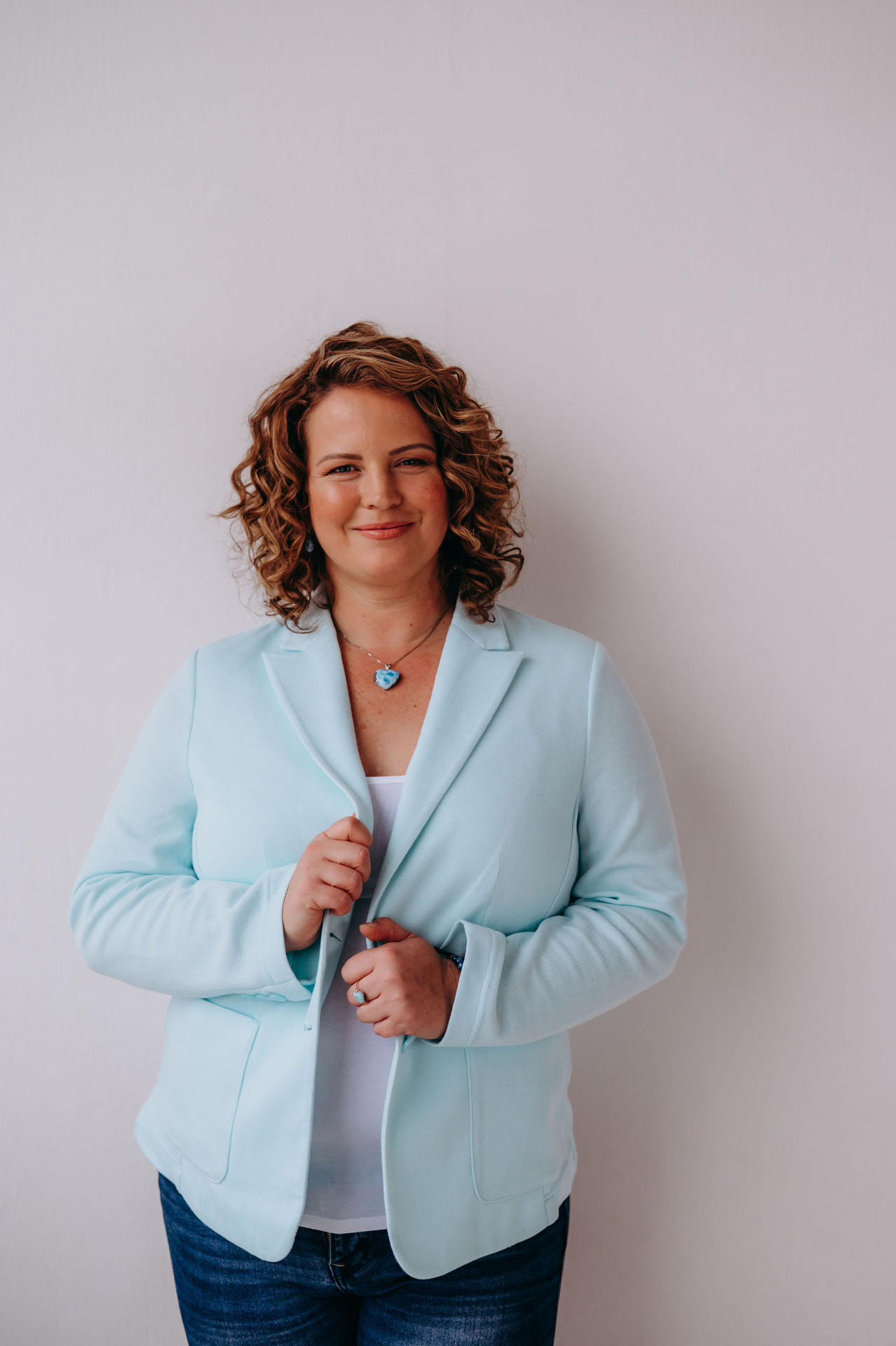 Portrait of host Petra Zlotá in a light blue blazer